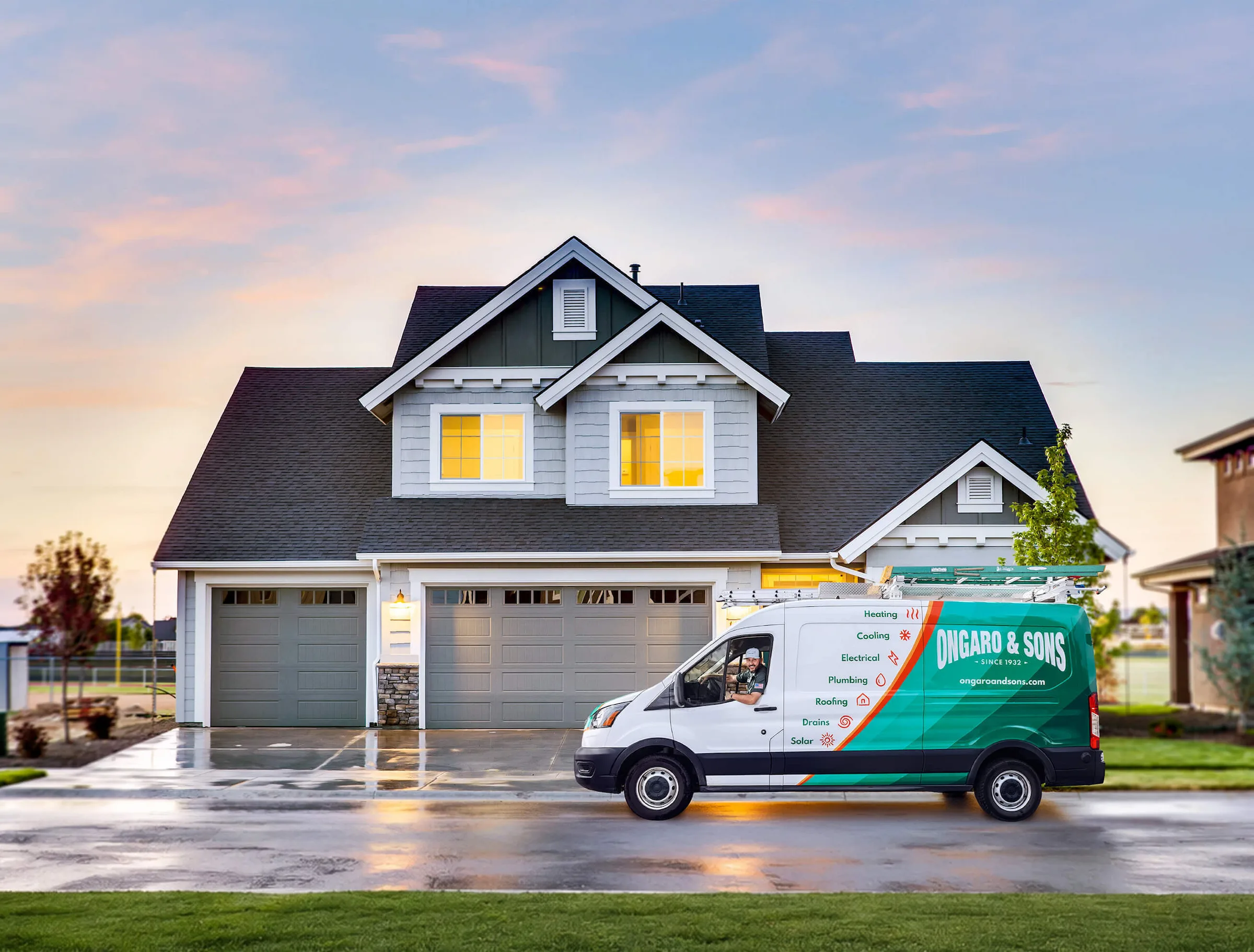 Ongaro & Sons service van parked in front of a two-story white house with garage at dusk.