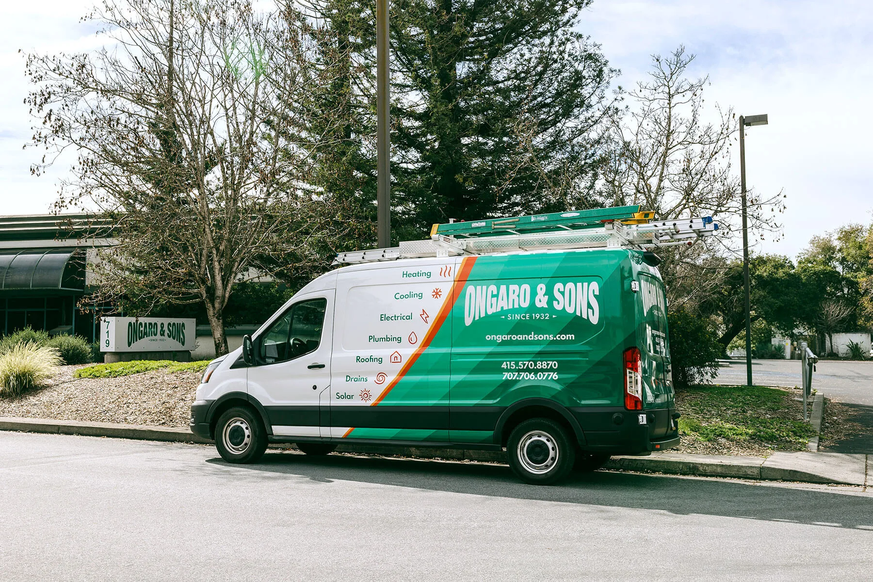 Ongaro & Sons service van parked on street with trees in background, displaying company branding and service offerings.