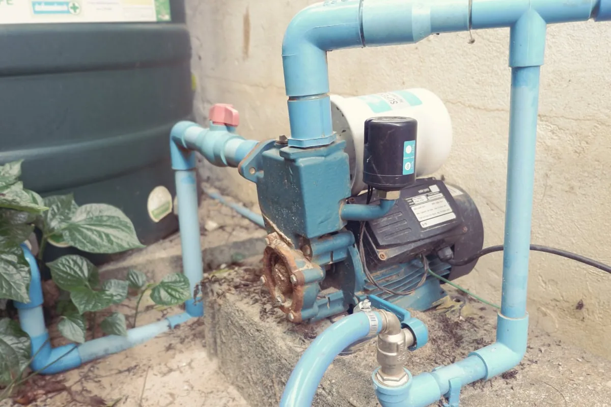 Water booster pump with pressure tank installed on residential plumbing lines.