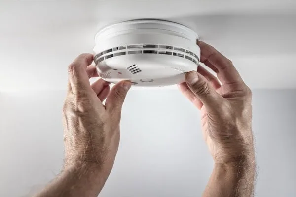 Home smoke and fire alarm detector being installed.