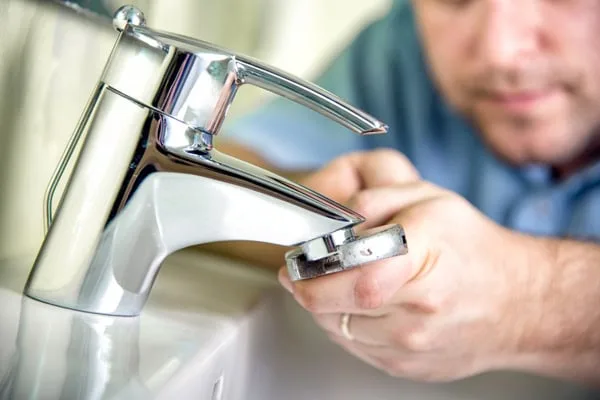Plumber repairing faucet spout