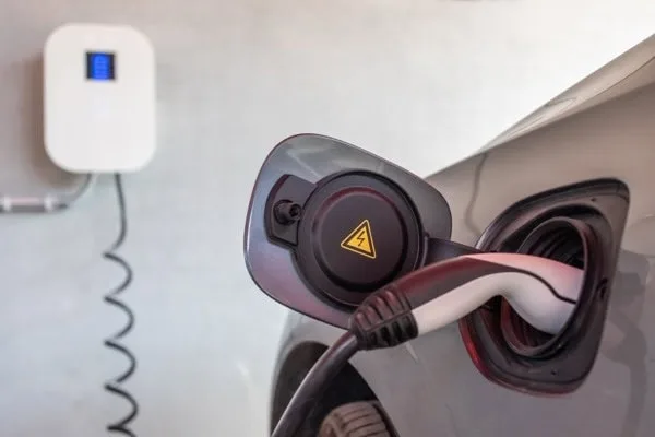 Electric car being charged in a garage with an installed wallbox.