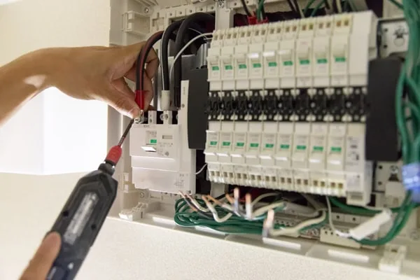 Electrician installing a surge protector into electrical panel.