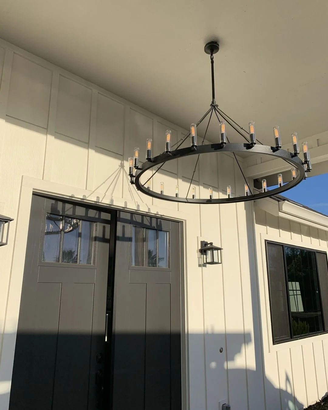 Round Edison-bulb chandelier installed in a home entryway by Ongaro & Sons