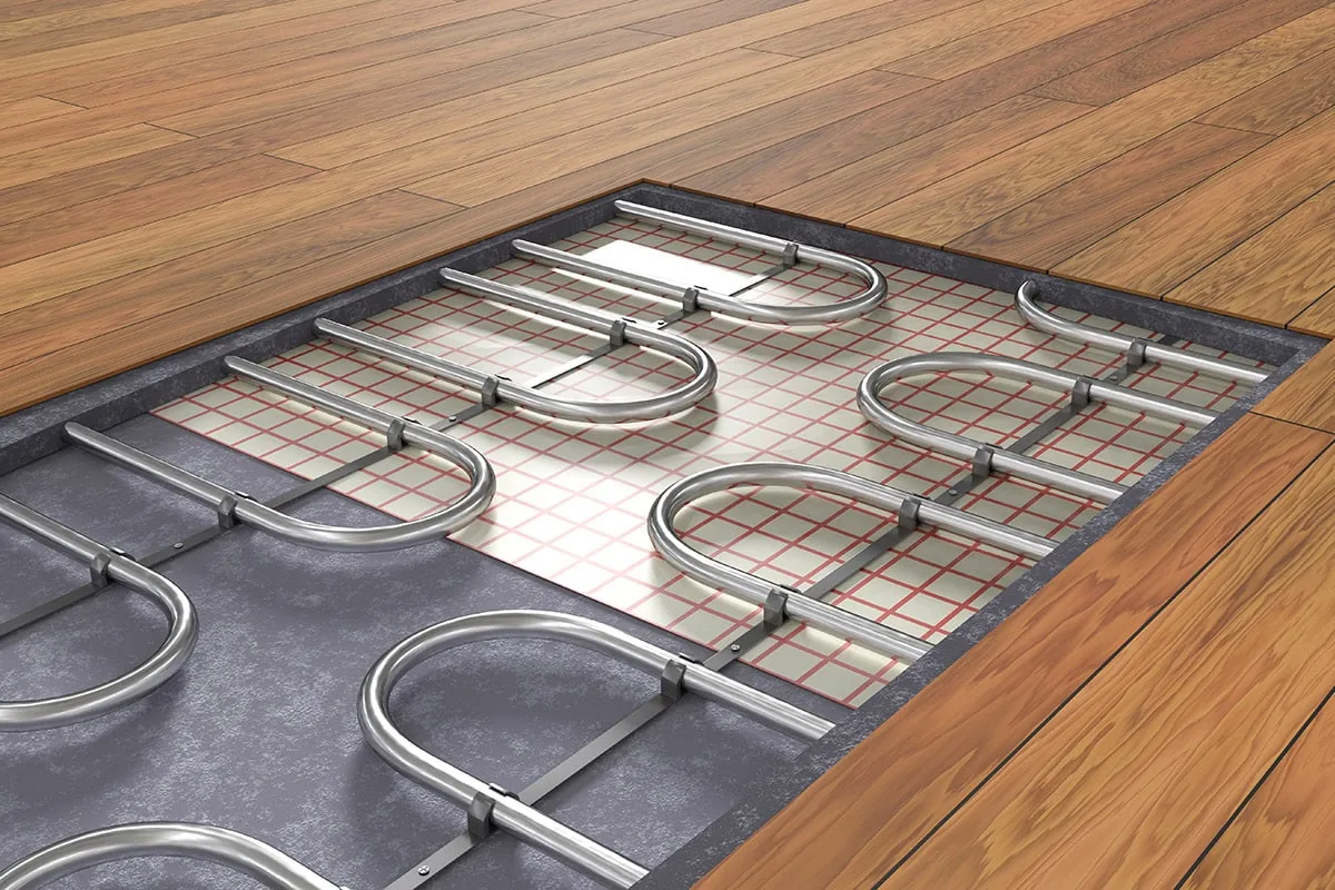 Radiant floor heating tubing laid out in even loops across a subfloor before finishing.