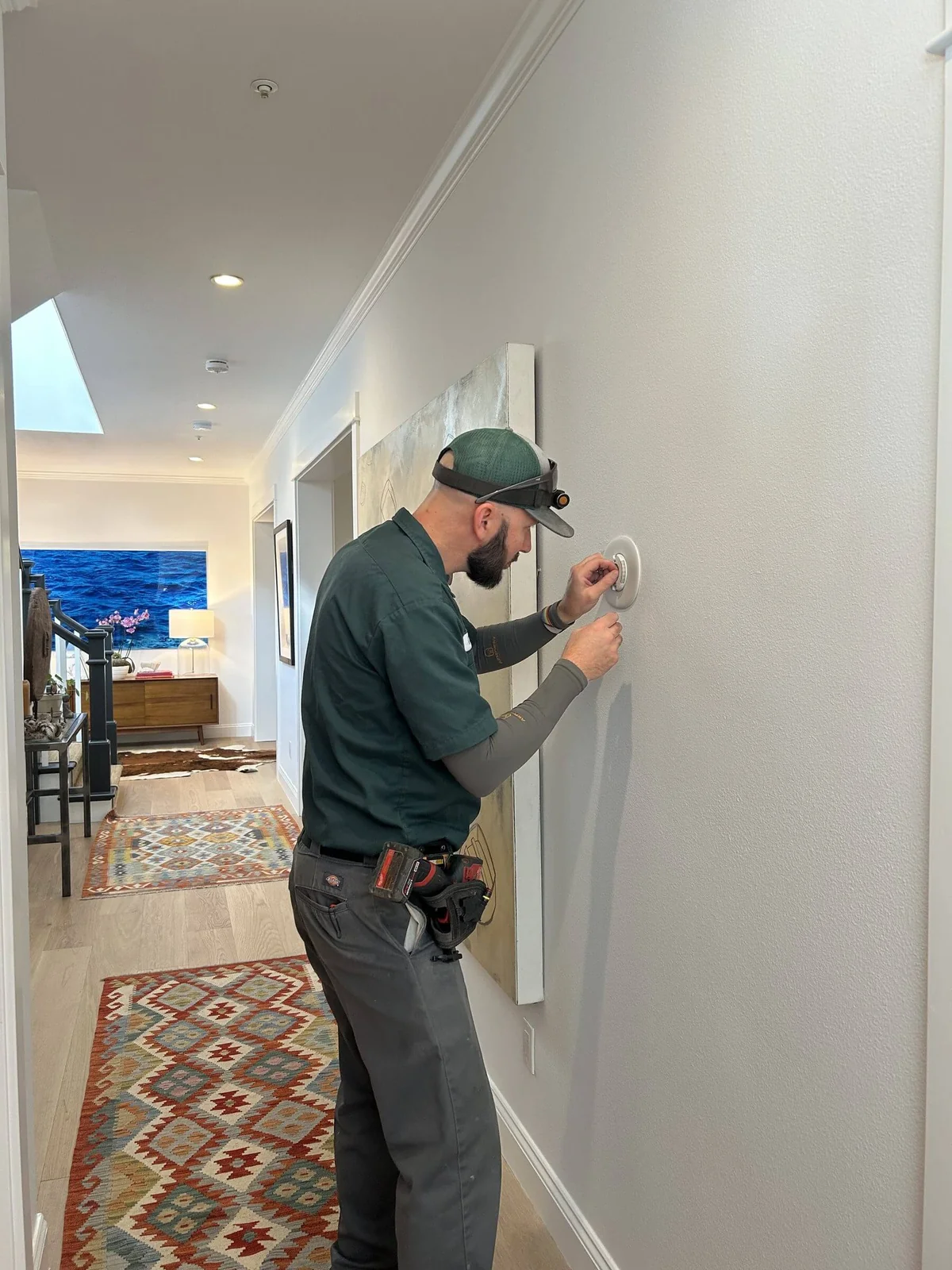 An Ongaro & Sons electrician installing a smoke detector