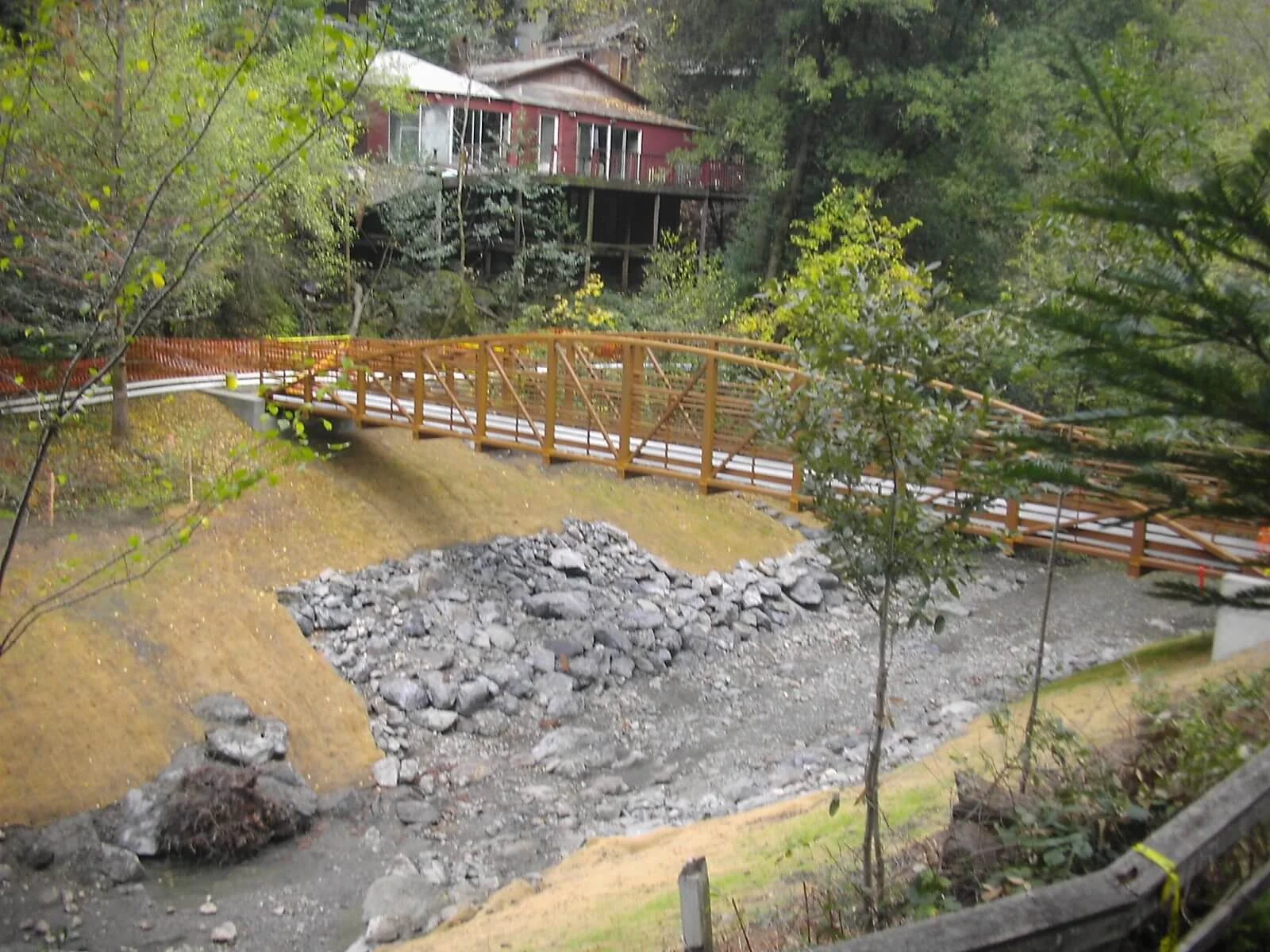 A cabin raised above Dutch Bill Creek at Camp Meeker, with the footbridge crossing below it
