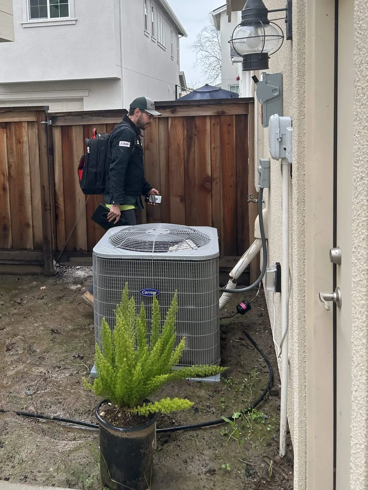 An Ongaro & Sons technician servicing a residential air conditioning condenser