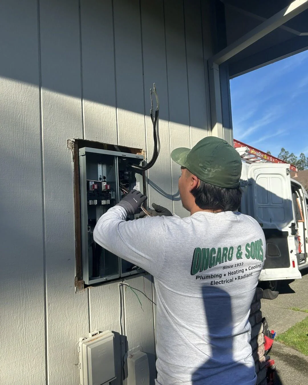 An Ongaro & Sons electrician installing an exterior subpanel