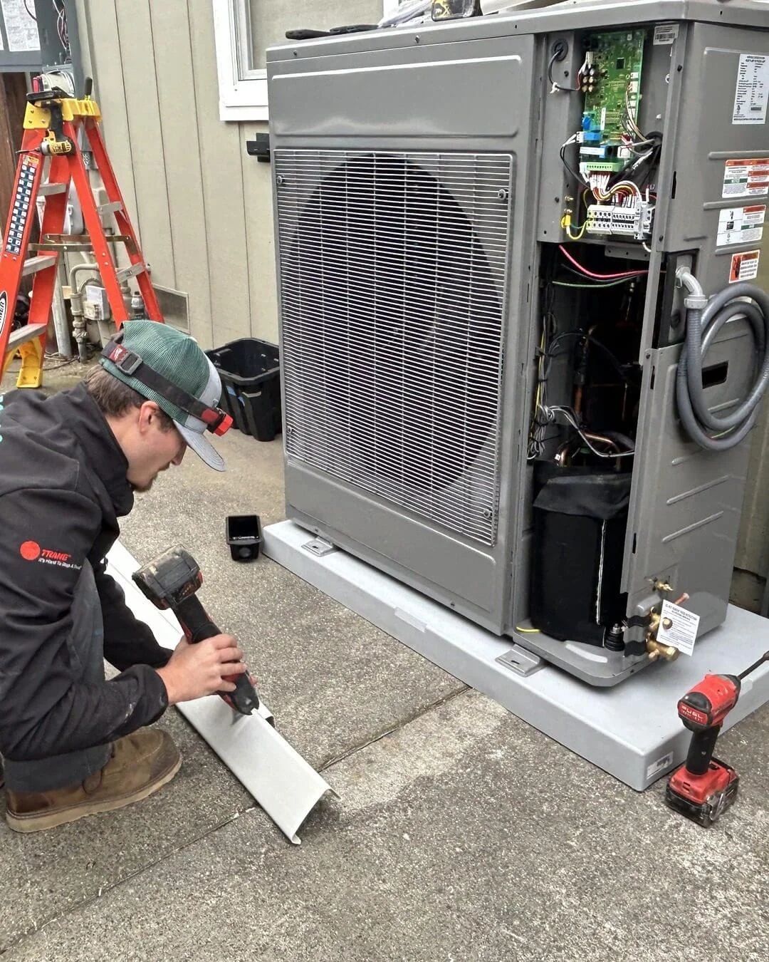 An Ongaro & Sons technician servicing a Trane heat pump