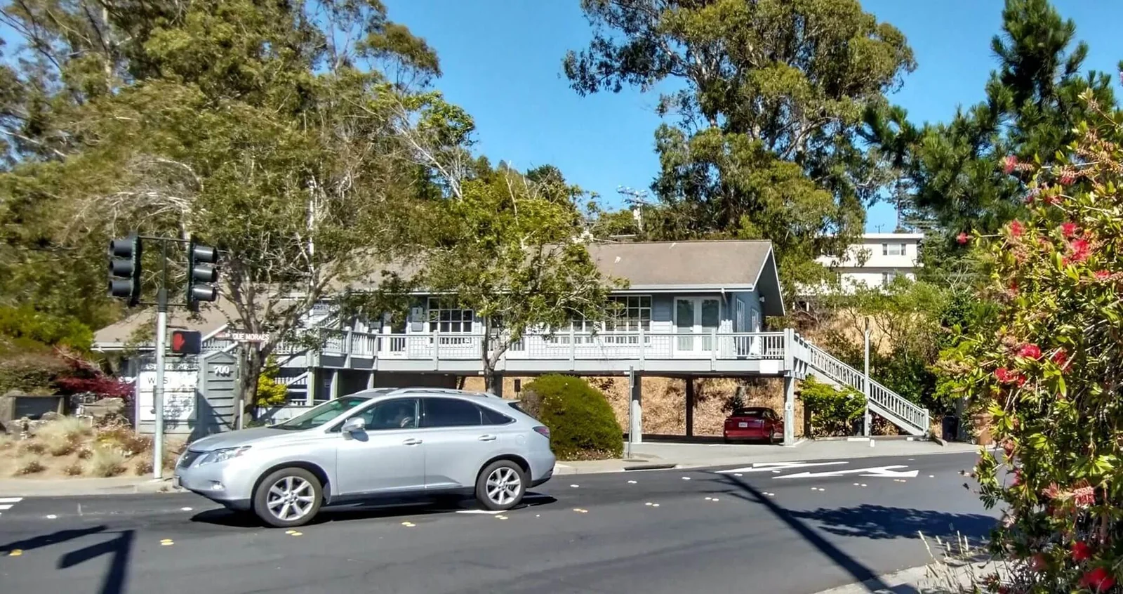 A wood building raised on stilts above a parking lot in Corte Madera