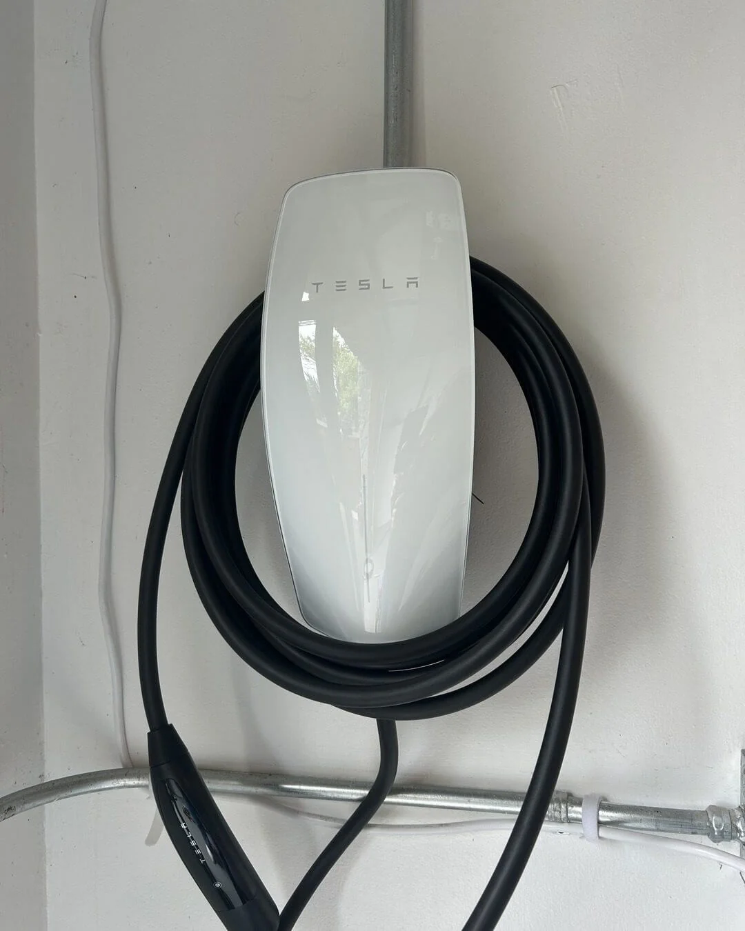 A wall-mounted EV charger installed at a home