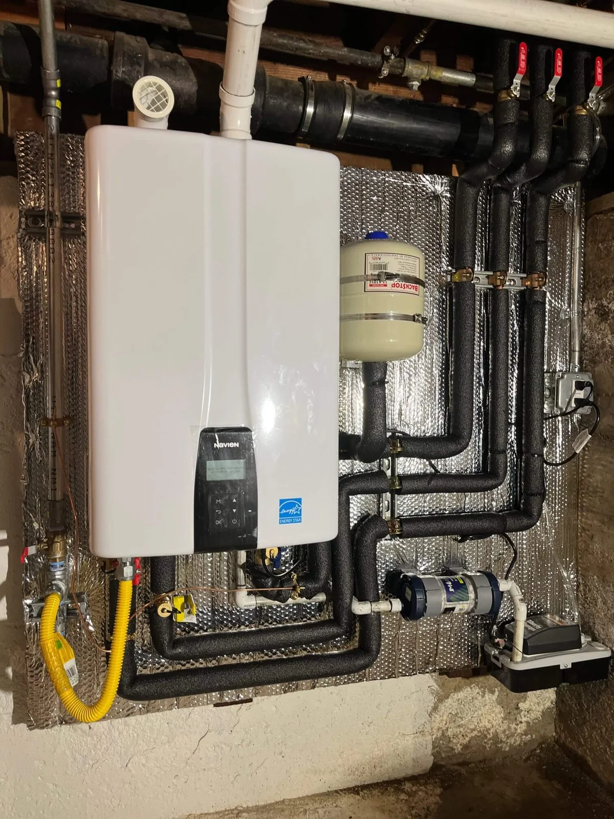 Navien tankless water heater with recirculation manifold in a basement mechanical room