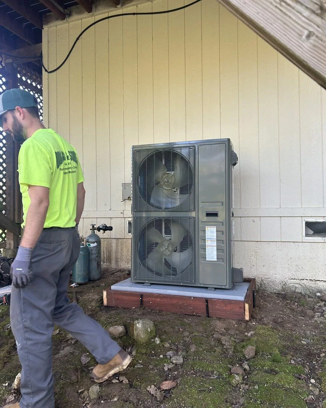 An Ongaro & Sons technician servicing a pad-mounted condenser
