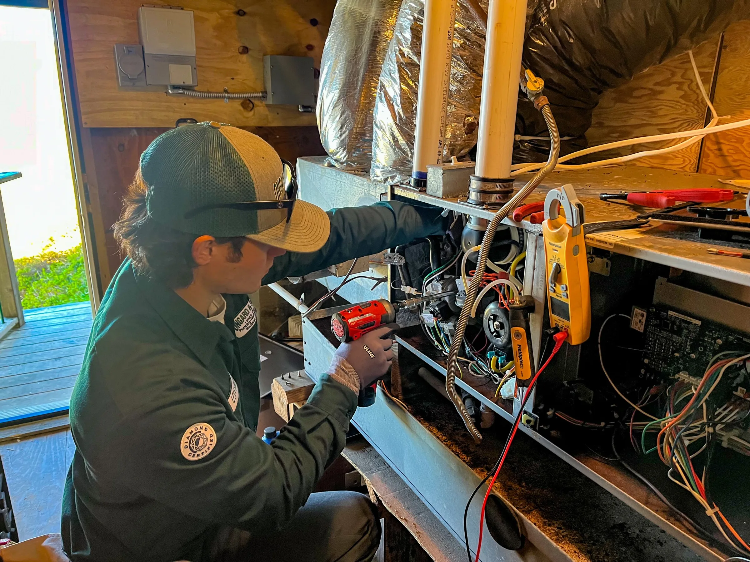 HVAC technician performing heater maintenance on residential unit in North Bay, using diagnostic tools and testing equipment.