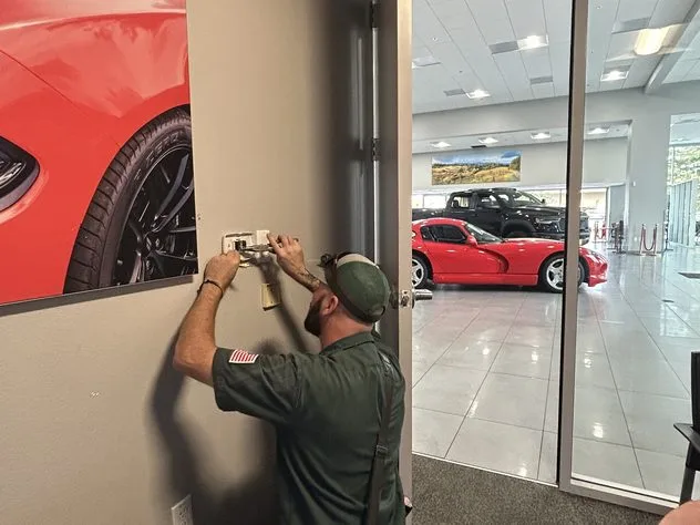 Ongaro & Sons technician wiring outlets in a business showroom