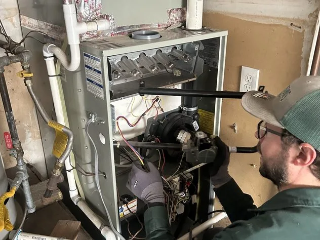 Ongaro & Sons technician servicing a furnace in a closet installation