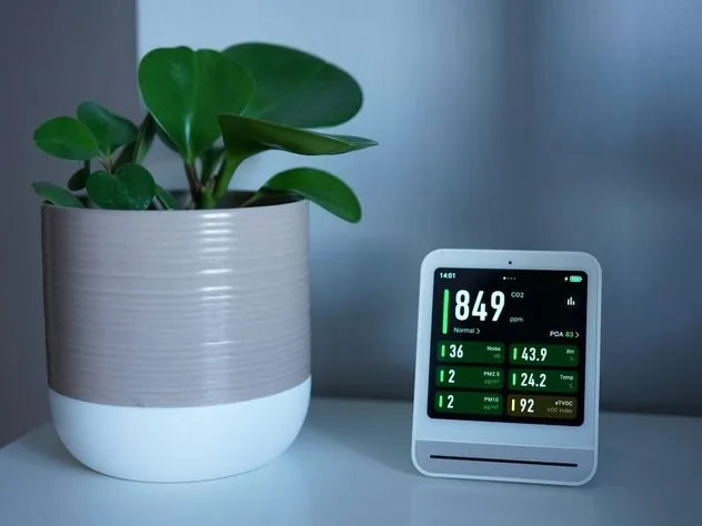 Indoor air quality monitor showing CO2 and particulate readings