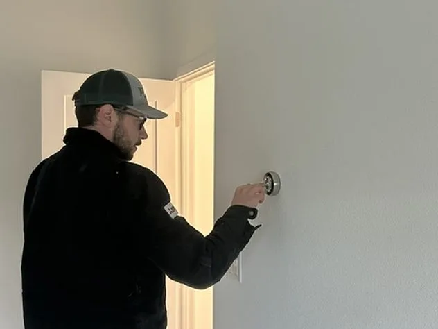 Ongaro & Sons technician installing a wall thermostat