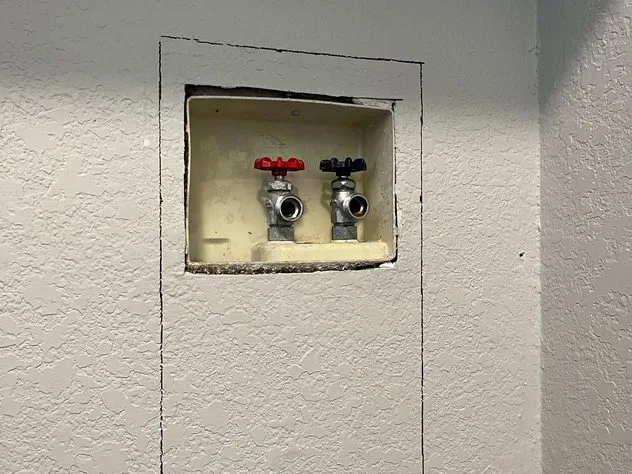 Old valves exposed during a laundry hookup repair