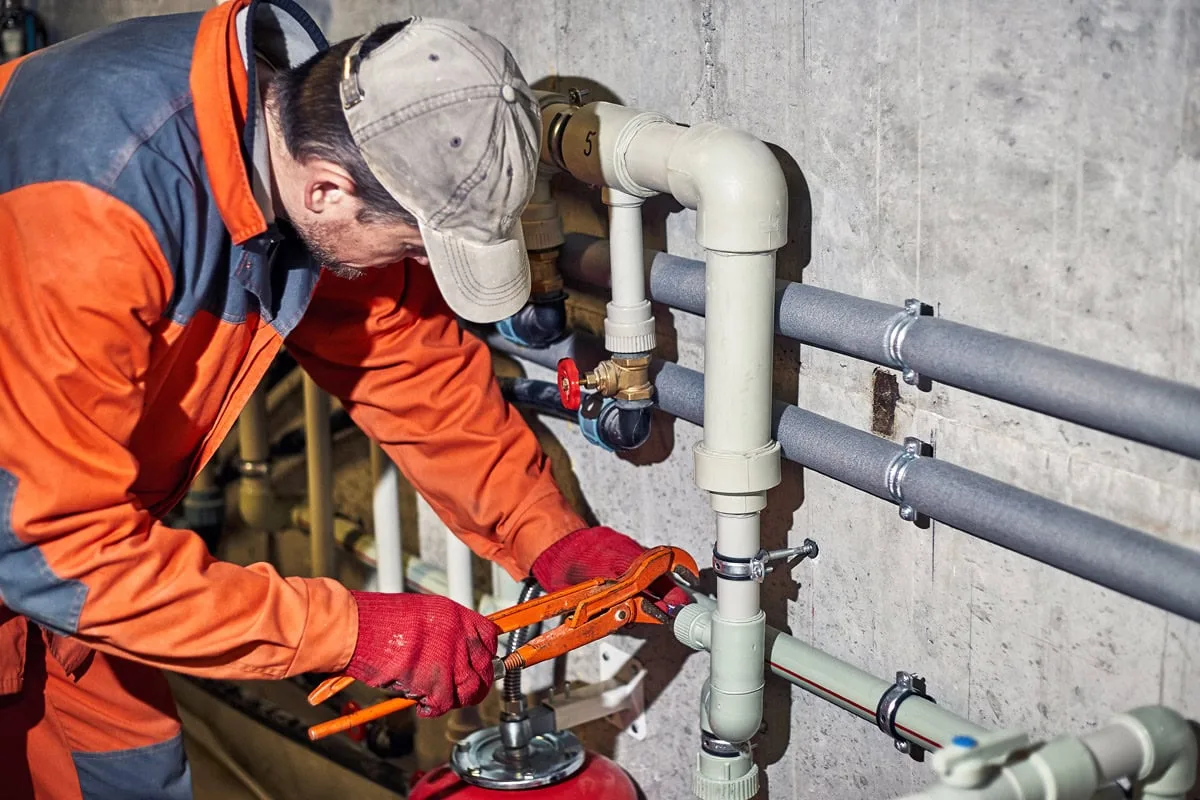 Plumber installing and replacing pipes