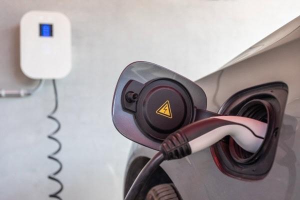 Electric car being charged in a garage with an installed wallbox.